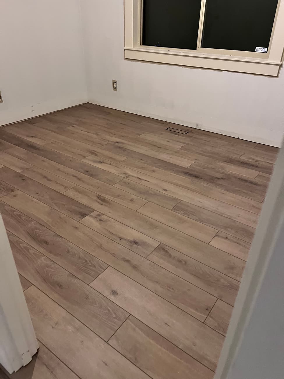 Plank flooring laid across a room, running square to the window wall