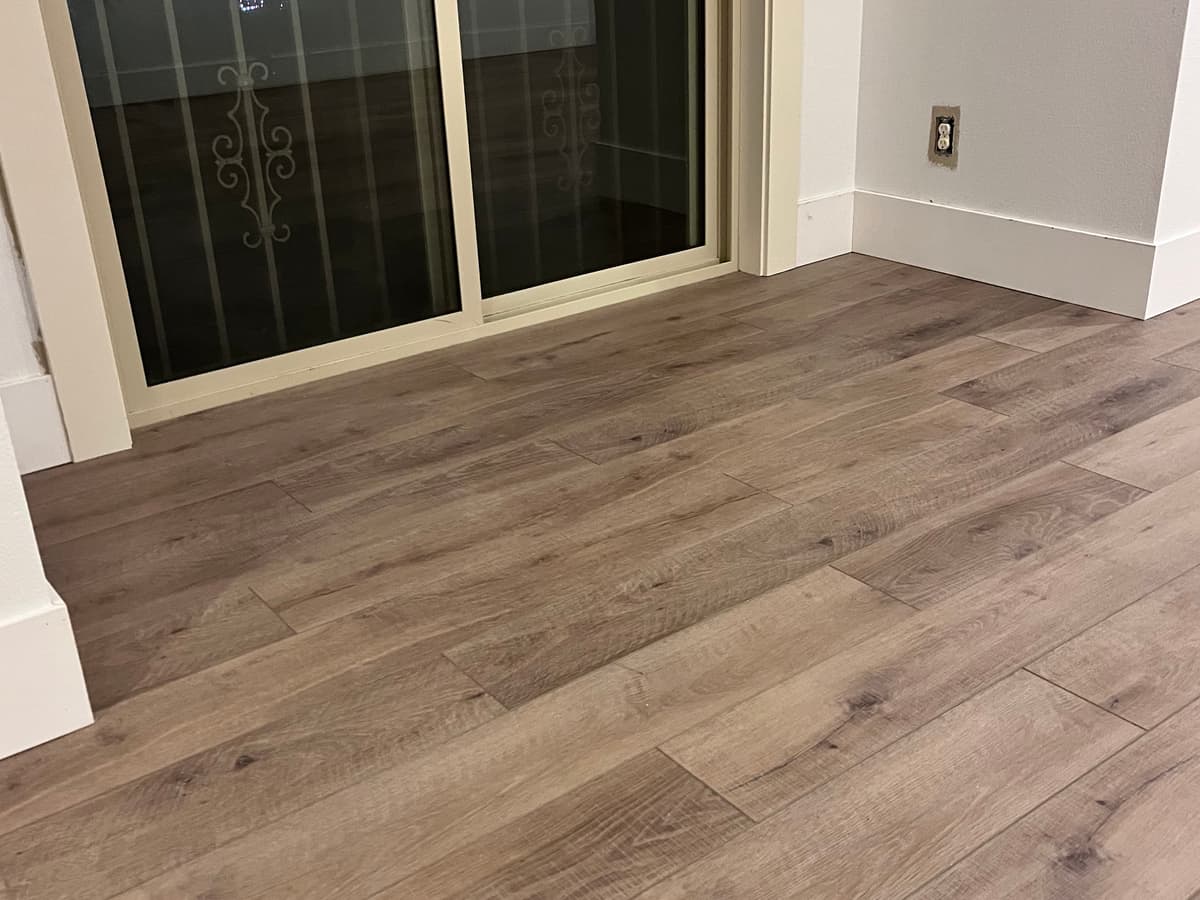 Newly laid plank flooring running to a sliding door, by Handy Brothers LLC