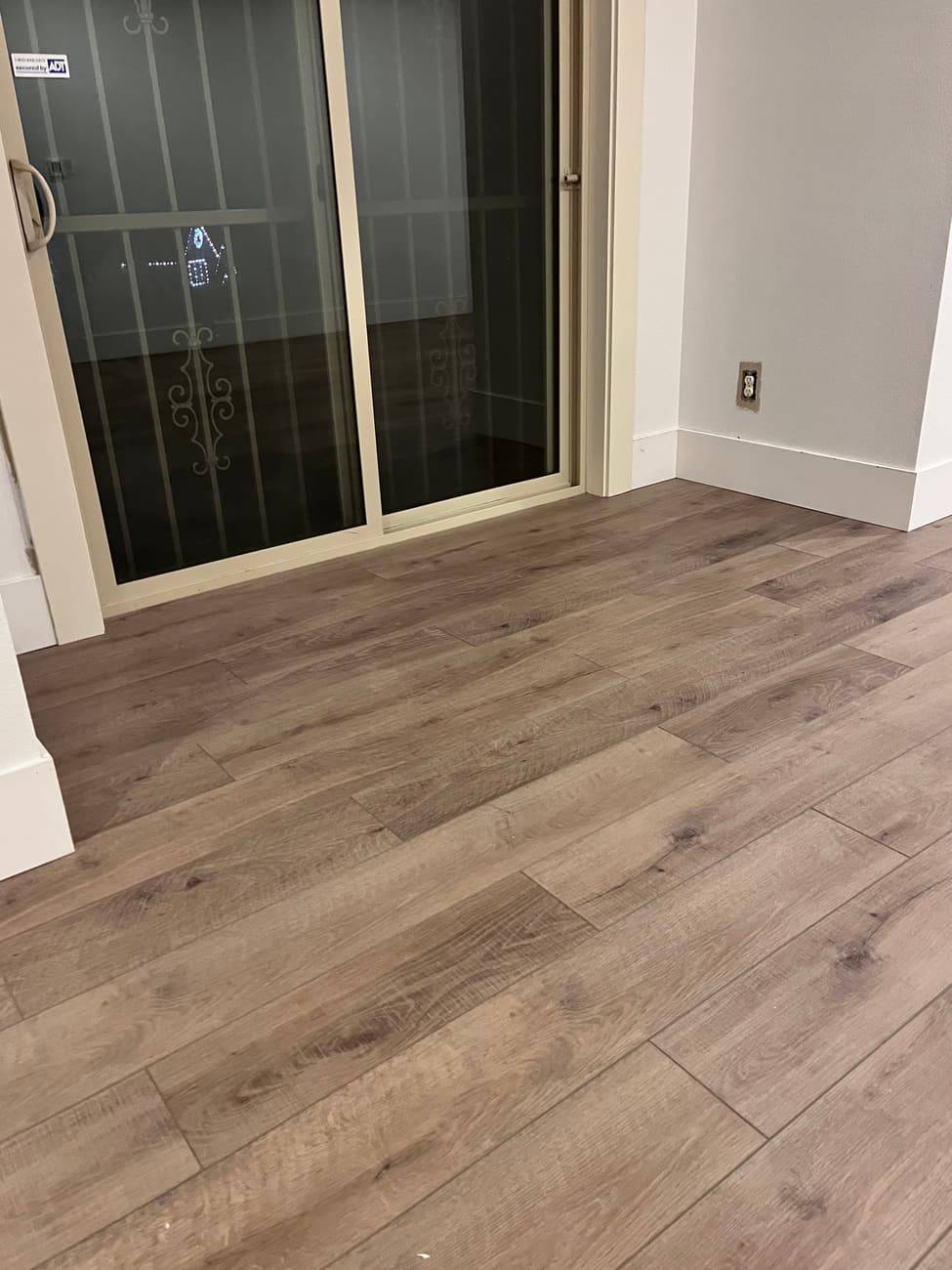 Newly laid plank flooring running up to a sliding glass door