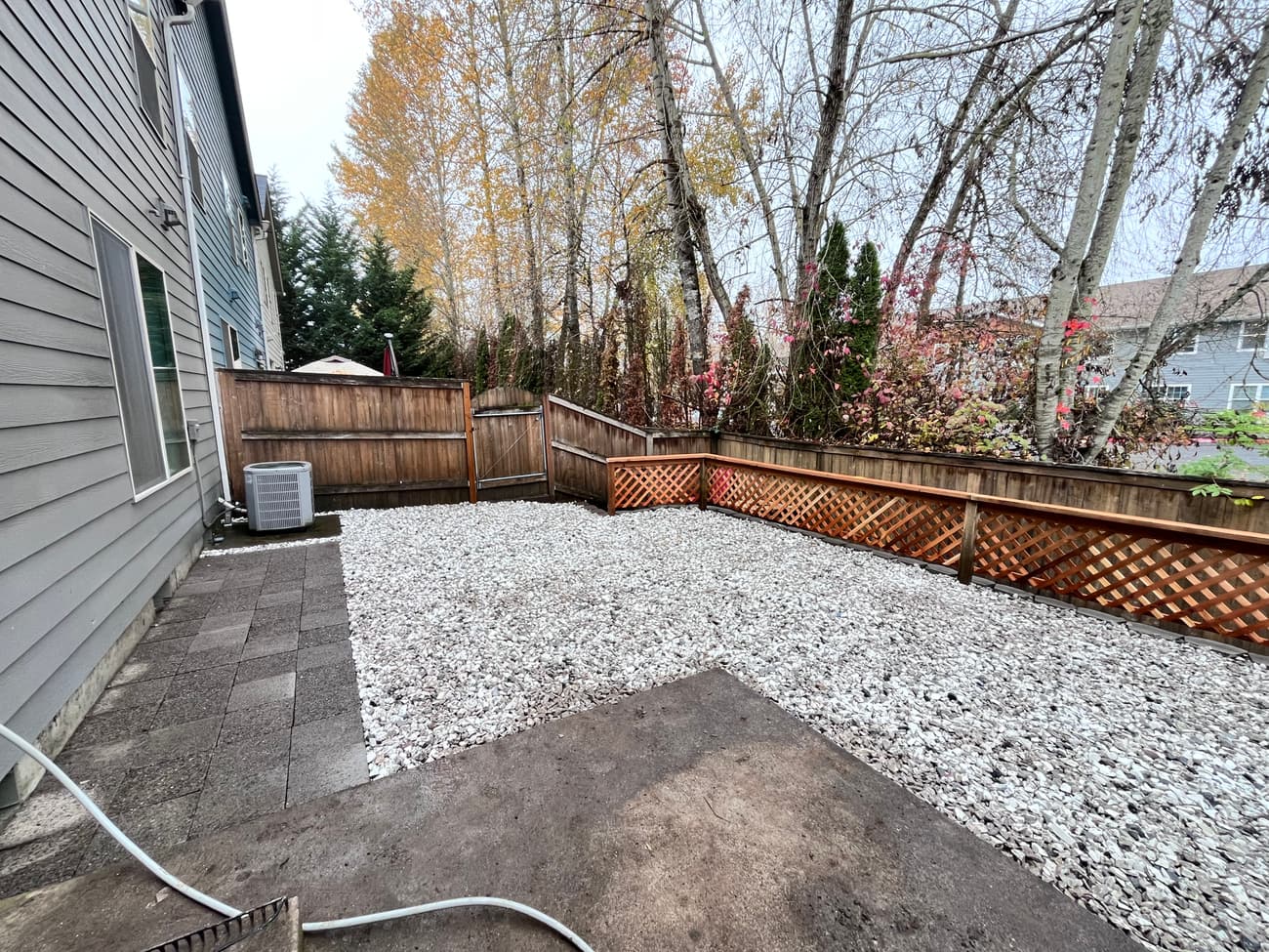 The same back yard after work: pavers laid against the house and the rest of the yard in gravel