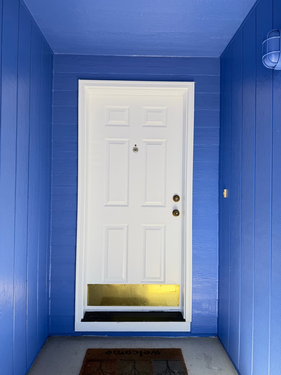 Close cut line between white door trim and blue siding